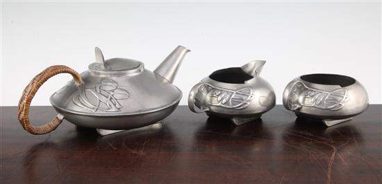 A Liberty Tudric pewter three piece tea set, no.0231, designed by Archibald Knox, teapot 9.75in.
